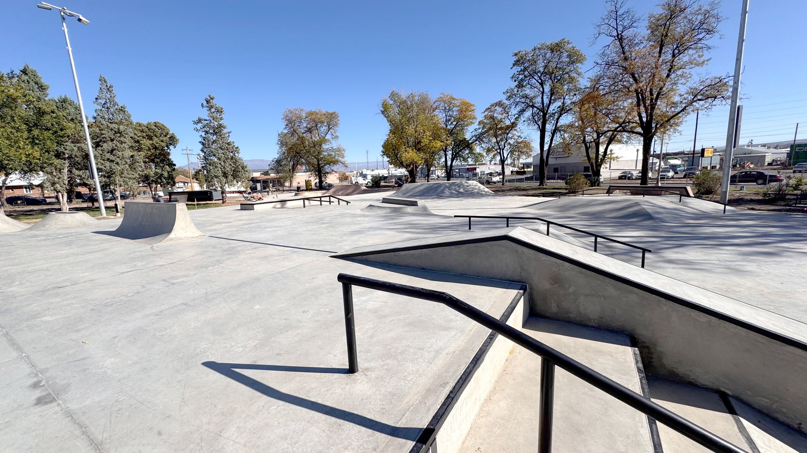 Picture of a skateboard park with obstacles for skateboarders to jump or slide off of.