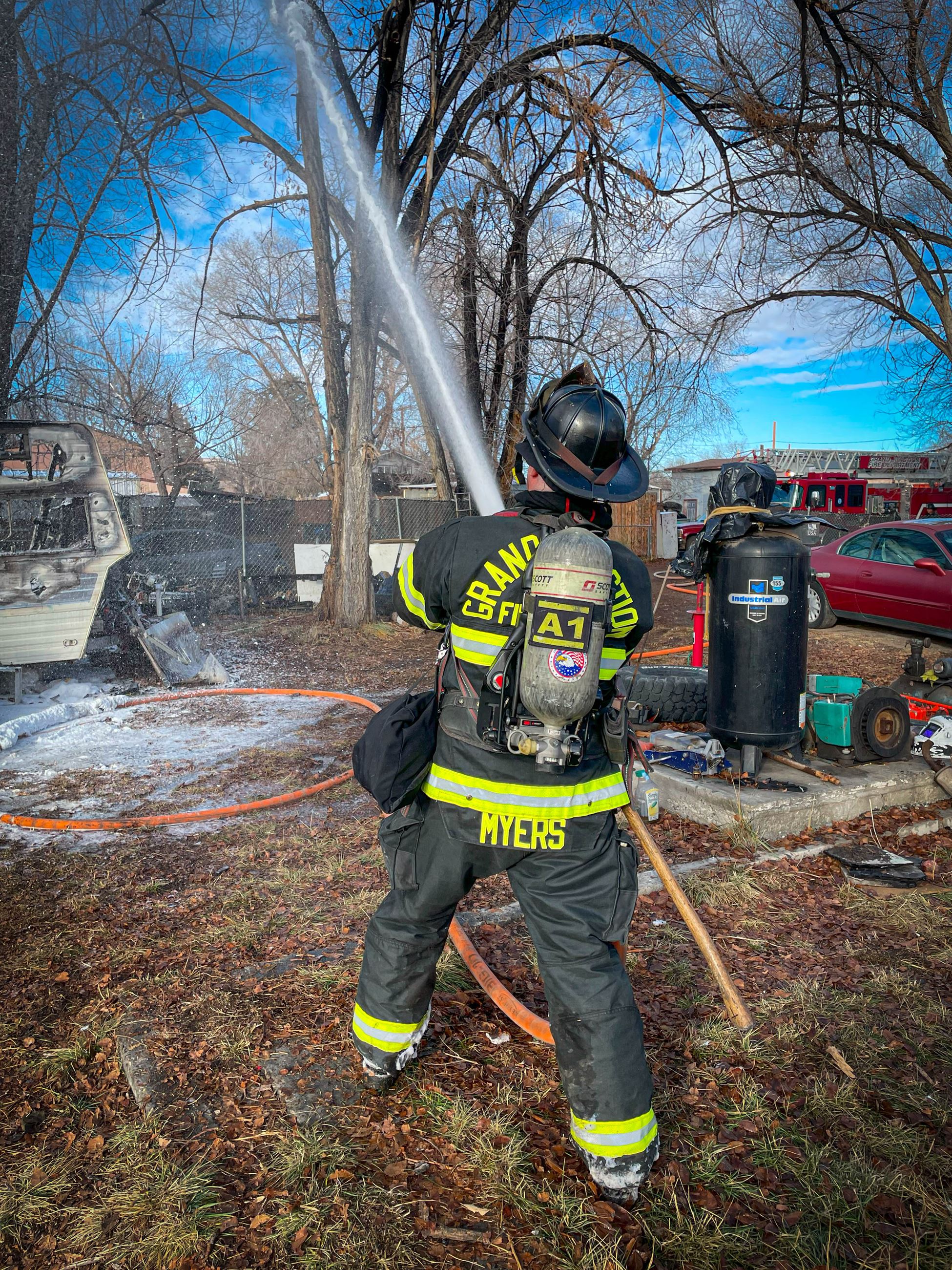 A firefighter extinguishes a tree on fire