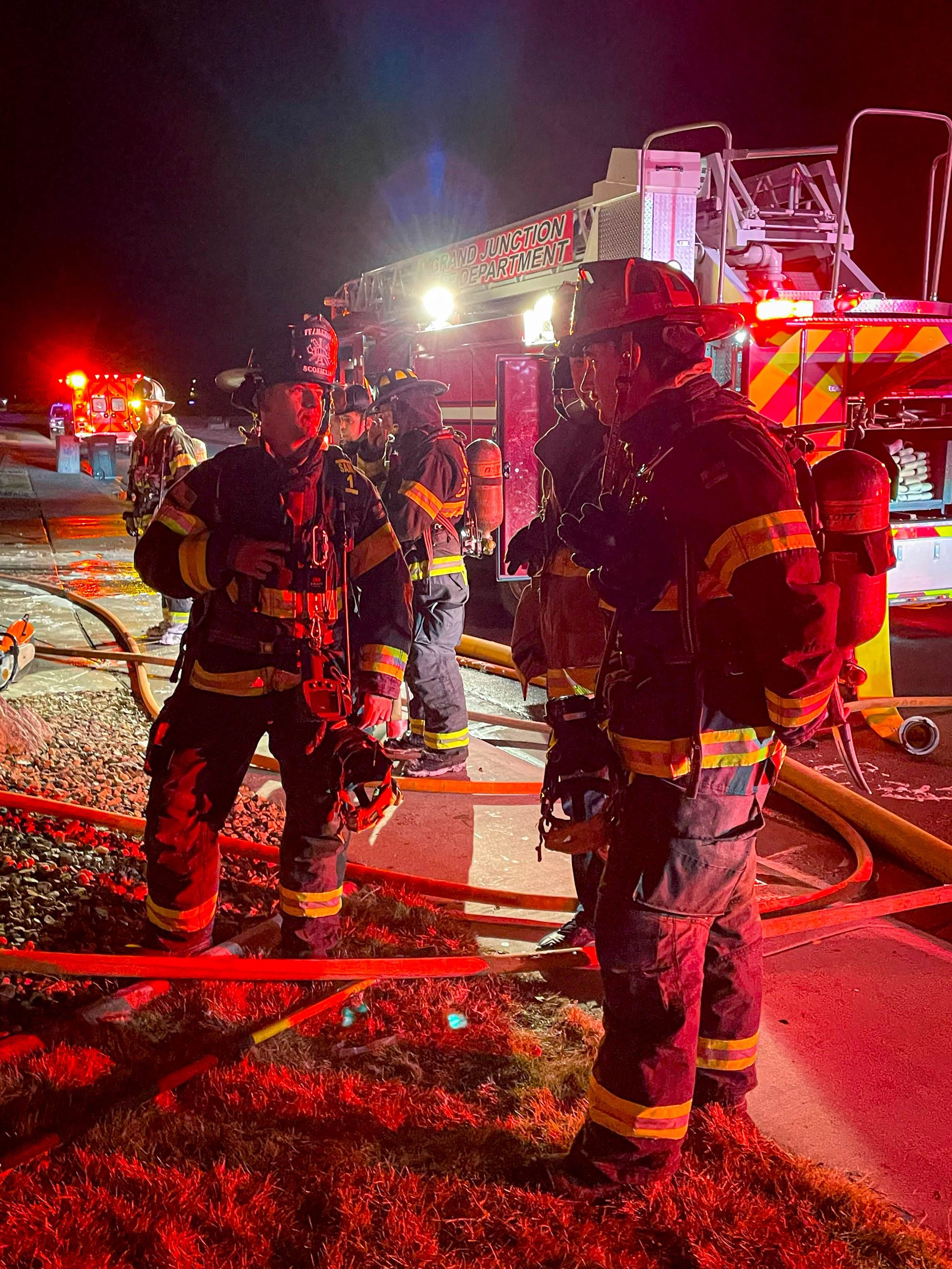 Firefighters talk after extinguishing a fire