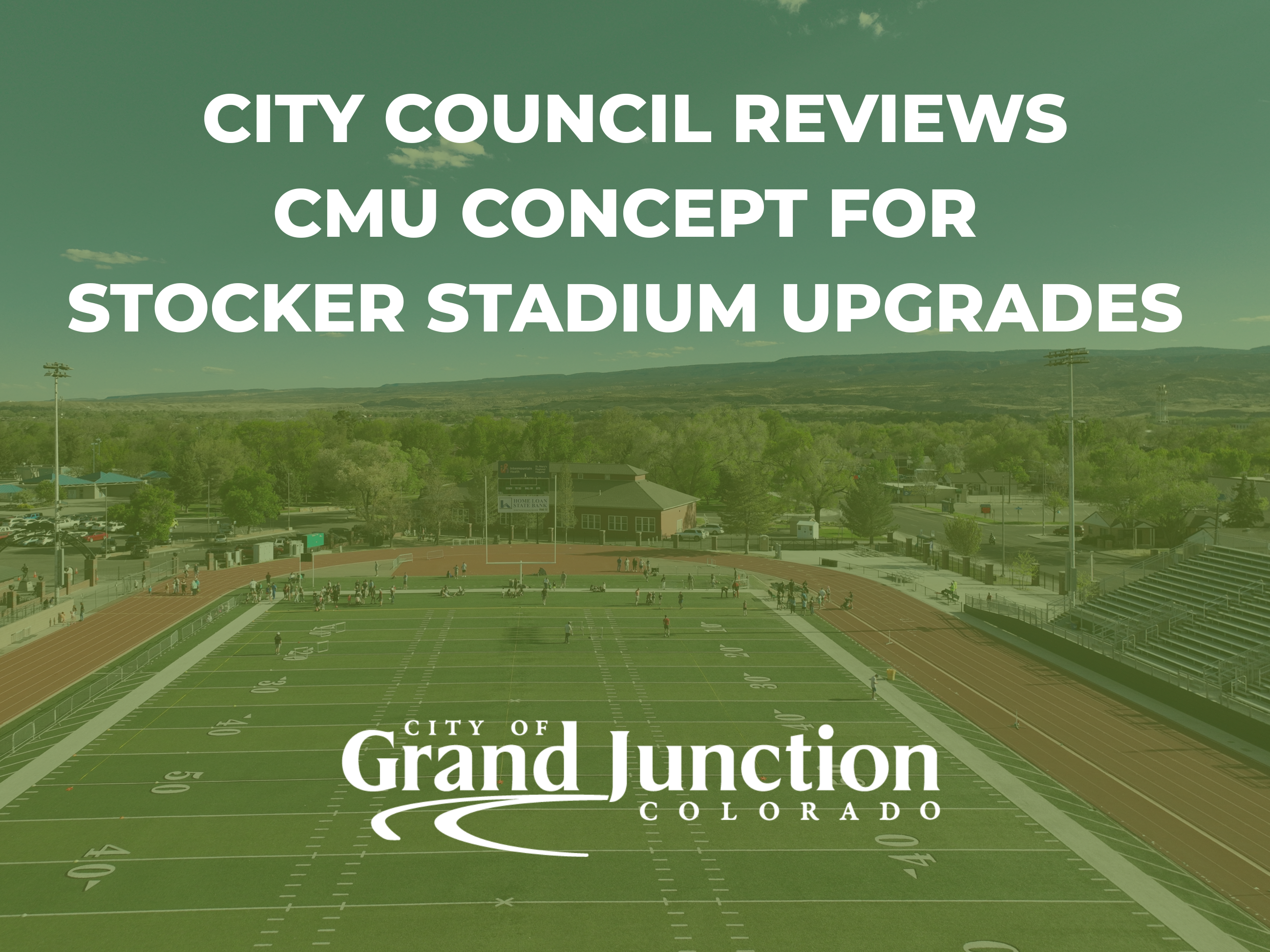 An aerial view of a football field with players on the turf. 