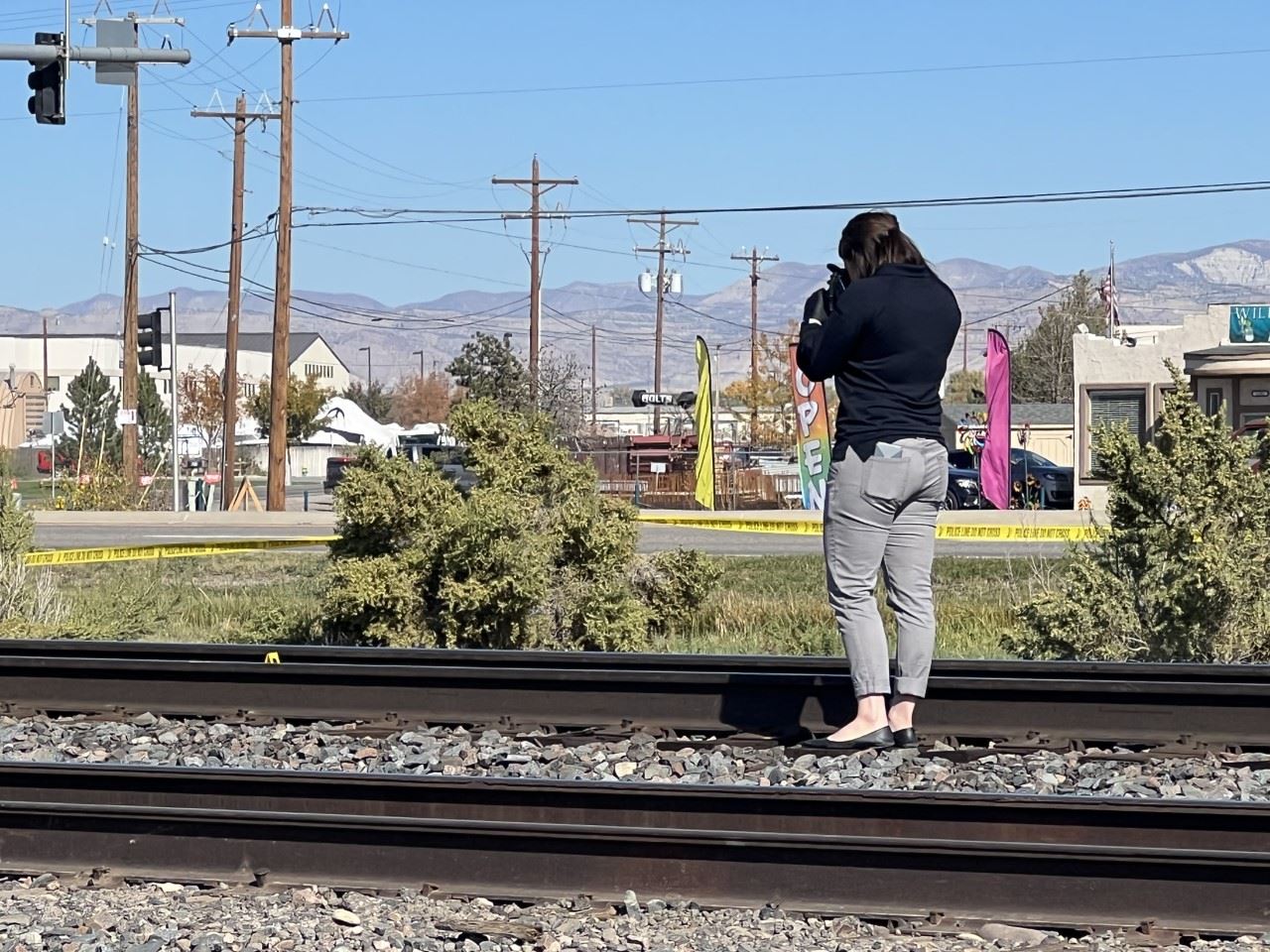 woman with camera taking pictures of train tracks