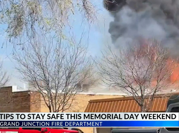 Picture of  news cast with a background of a house fire