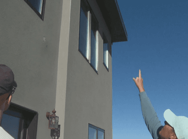 man pointing to roof to where the lighting hit the house