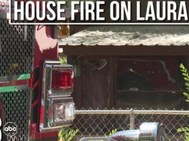 Picture of the back of a fire truck next to burned house