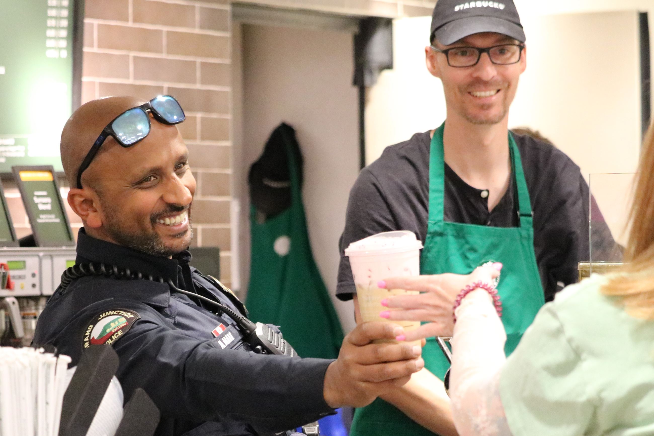 Officer handing community member a coffee